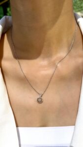 Delicate white gold chain featuring a circular pendant encrusted with diamonds